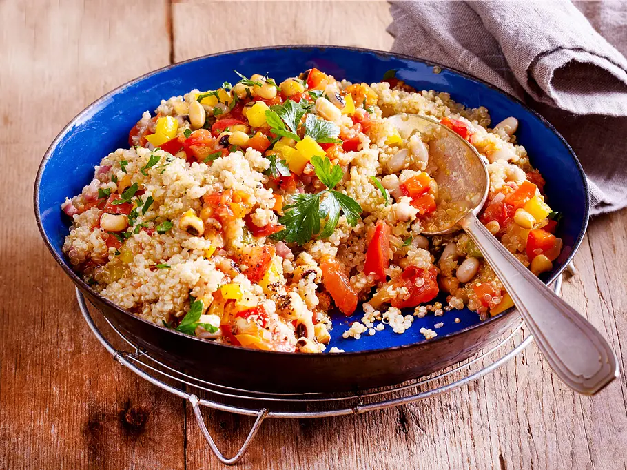 Quinoa-Gemüse-Pfanne Rezept Quinoa-Gemüse-Pfanne in einer blauen Emaillepfanne mit Esslöffel darin
