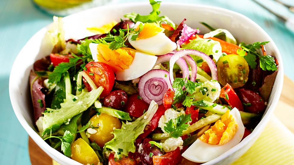 Schneller Salat mit Ei und Feta in einer weißen Schüssel, im Hintergrund steht ein Olivenöl-Fläschchen - Foto: House of Food / Bauer Food Experts KG