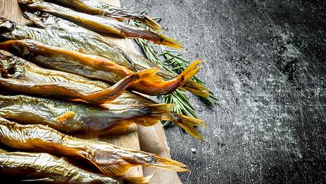 Geräucherter Fisch auf einem Holzbrett im rustikalen Hintergrund - Foto: iStock/Olesia Shadrina