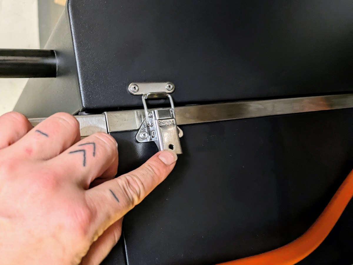 Eine Hand schließt die seitliche Verriegelung am Gehäuse des Videro G2-P, der orange Gasschlauch ist sichtbar.