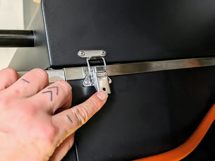 Rösle Videro G2-P Schnalle Eine Hand schließt die seitliche Verriegelung am Gehäuse des Videro G2-P, der orange Gasschlauch ist sichtbar.