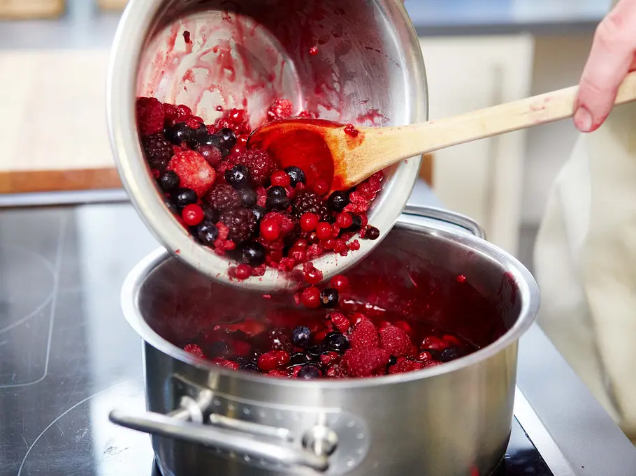 Rote Grütze zubereiten Rote Grütze fürs Milchreis-Tiramisu zubereiten: Früchte werden zum Saft in den Topf gegeben.