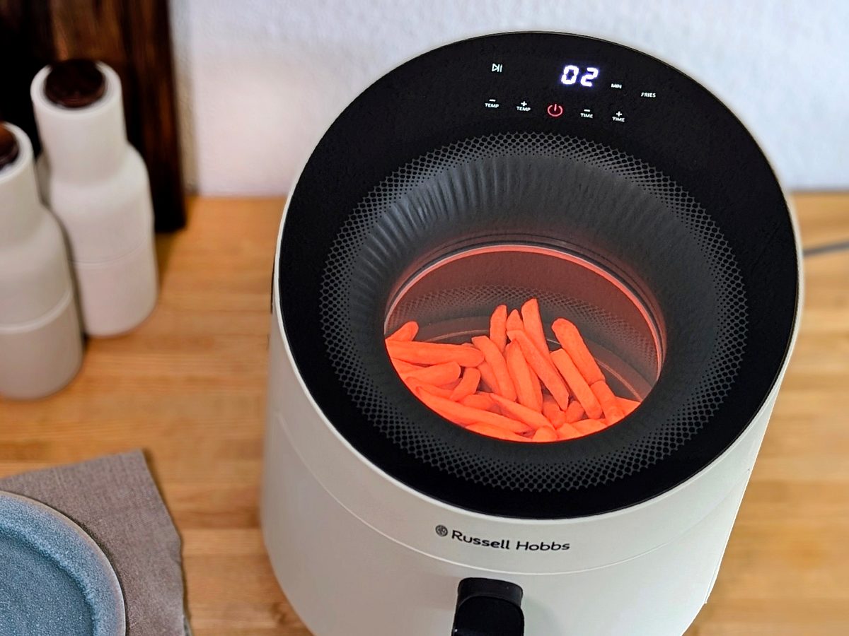 Der Russell Hobbs Satisfry Panoramic Airfryer, von oben fotografiert – mit Blick durch das Sichtfenster auf TK-Pommes bei der Zubereitung