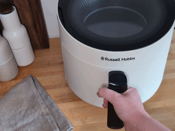 Hähnchenschenkel werden samt Schublade aus dem Russell Hobbs Satisfry Panoramic Airfryer gezogen