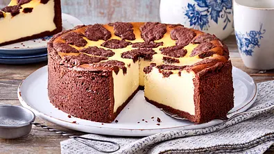 Angeschnittener russischer Zupfkuchen liegt auf einem großen runden Teller, im Hintergrund ist blau-weißes Porzellan zu sehen - Foto: LECKER @ Bauer Media Group