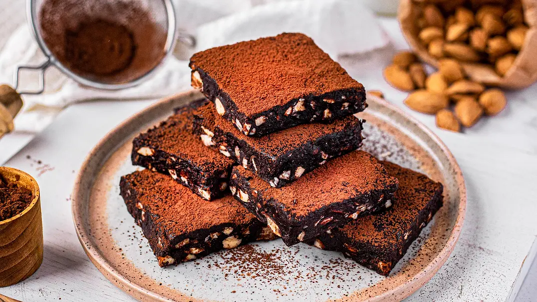 Sechs übereinander gestapelte, quadratische Stücke Brownies mit Kakao bestäubt - Foto: ShowHeroes für LECKER @ Bauer Media Group Sechs übereinander gestapelte, quadratische Stücke Brownies mit Kakao bestäubt - Foto: ShowHeroes für LECKER @ Bauer Media Group