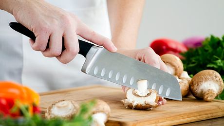 Eine Person schneidet Pilze mit einem Santoku-Messer - Foto: iStock/nicolesy