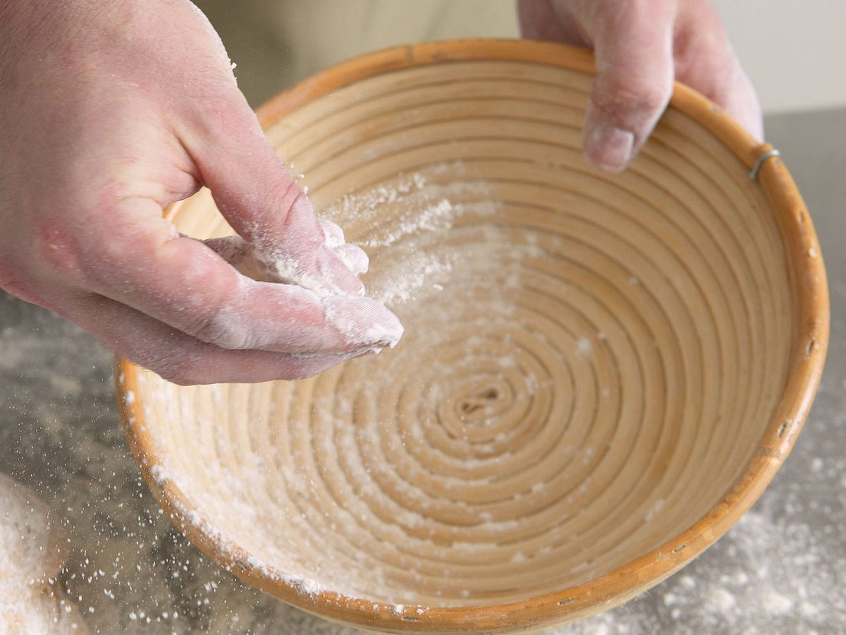 Sauerteigbrot backen: Gärkorb mit Mehl ausstreuen