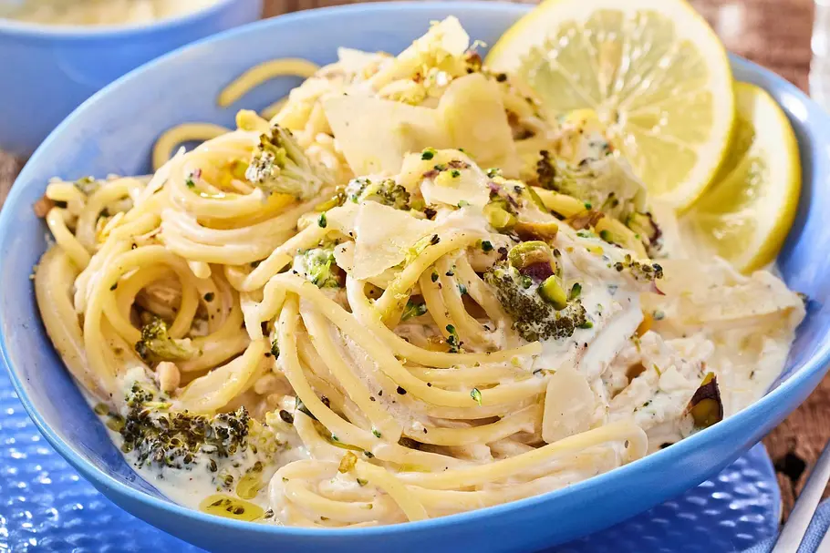 Brokkoli-Spaghetti mit Zitronen-Cremesoße in einer blauen Schüssel.