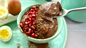 Eine Schale mit angelöffeltem Protein-Schokopudding mit einem Granatapfel-Topping und ein Löffel voll cremigem Pudding - Foto: LECKER @ Bauer Media Group / Nicole Molitor Eine Schale mit angelöffeltem Protein-Schokopudding mit einem Granatapfel-Topping und ein Löffel voll cremigem Pudding - Foto: LECKER @ Bauer Media Group / Nicole Molitor