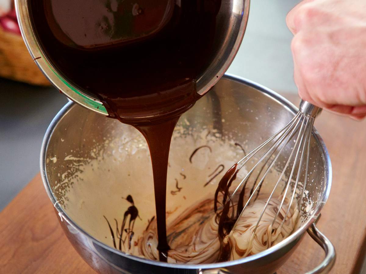 Geschmolzene Schokolade unter das aufgeschlagene Ei rühren