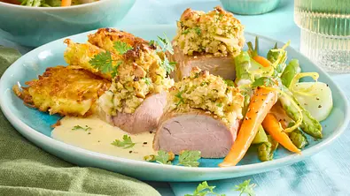 Zartes Schweinefilet, überbacken mit einer goldbraunen Crumble-Kruste, serviert auf cremiger Sauce und mit buntem Frühlingsgemüse angerichtet. - Foto: LECKER @ Bauer Media Group