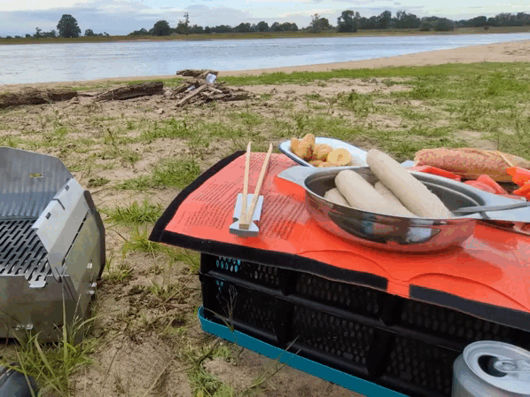 Nürnberger Bratwürstchen wird mit den SKOTTI Tongs auf den SKOTTI Camping-Grill gelegt.
