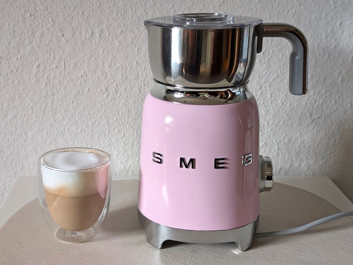 Der Smeg Milchaufschäumer neben einem Glas Cappuccino