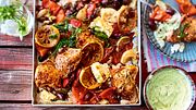 Hähnchenschenkel auf einem Blech mit Zitronenscheiben, Tomate und Oliven - Foto: House of Food / Bauer Food Experts KG