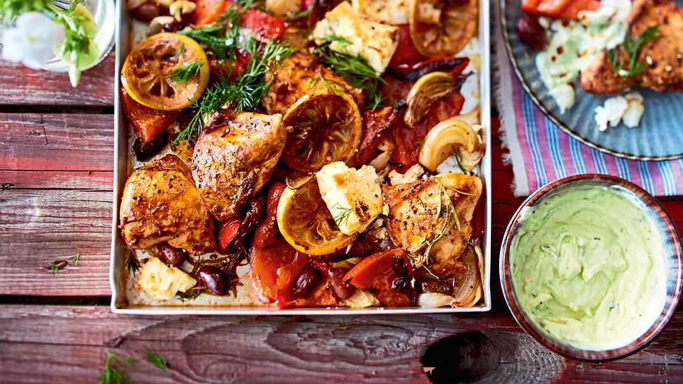 Hähnchenschenkel auf einem Blech mit Zitronenscheiben, Tomate und Oliven - Foto: House of Food / Bauer Food Experts KG
