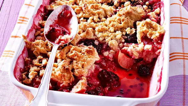 Angelöffeltes Pflaumen-Crumble in einer weißen Auflaufform - Foto: LECKER @ Bauer Media Group Angelöffeltes Pflaumen-Crumble in einer weißen Auflaufform - Foto: LECKER @ Bauer Media Group