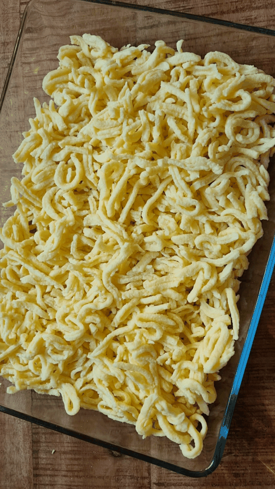 Spätzle, Erbsen, Fleisch, Pilze und Soße werden in die Auflaufform gegeben und vermengt.