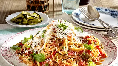 Ein Teller mit Spaghetti und stückigen Tomaten mit Parmesan und Basilkum garniert. - Foto: LECKER @ Bauer Media Group