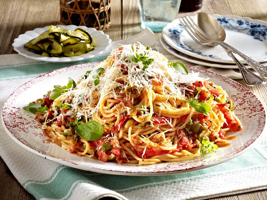 Spaghetti mit No-cook-Tomatensoße Rezept Ein Teller mit Spaghetti und stückigen Tomaten mit Parmesan und Basilkum garniert.