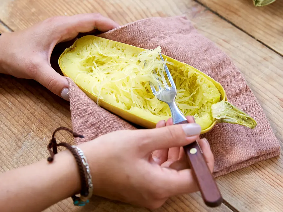 Fruchtfleisch des Spaghettikürbis von der Schale lösen Fruchtfleisch mit einer Gabel von der Schale lösen