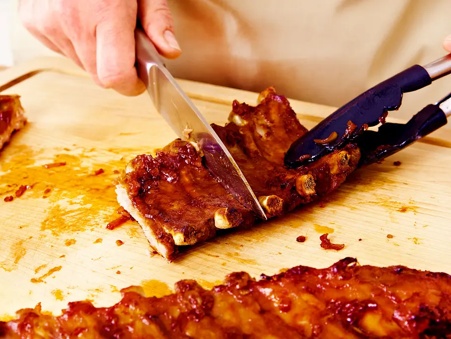 Spareribs schneiden Die gegrillten Spareribs werden in Stücke geschnitten