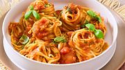 Die langen Nudeln sind von der Spezialsoße ummantelt und sind auf einem weißten tiefen Teller serviert - Foto: House of Food / Bauer Food Experts KG