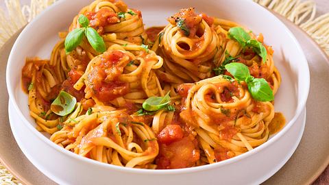Die langen Nudeln sind von der Spezialsoße ummantelt und sind auf einem weißten tiefen Teller serviert - Foto: House of Food / Bauer Food Experts KG