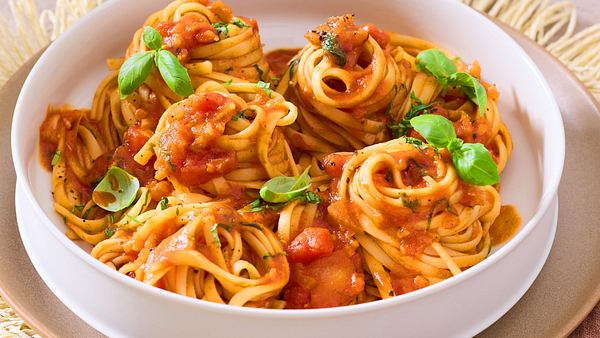 Die langen Nudeln sind von der Spezialsoße ummantelt und sind auf einem weißten tiefen Teller serviert - Foto: House of Food / Bauer Food Experts KG