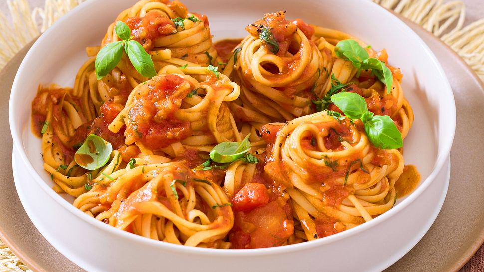Die langen Nudeln sind von der Spezialsoße ummantelt und sind auf einem weißten tiefen Teller serviert - Foto: House of Food / Bauer Food Experts KG