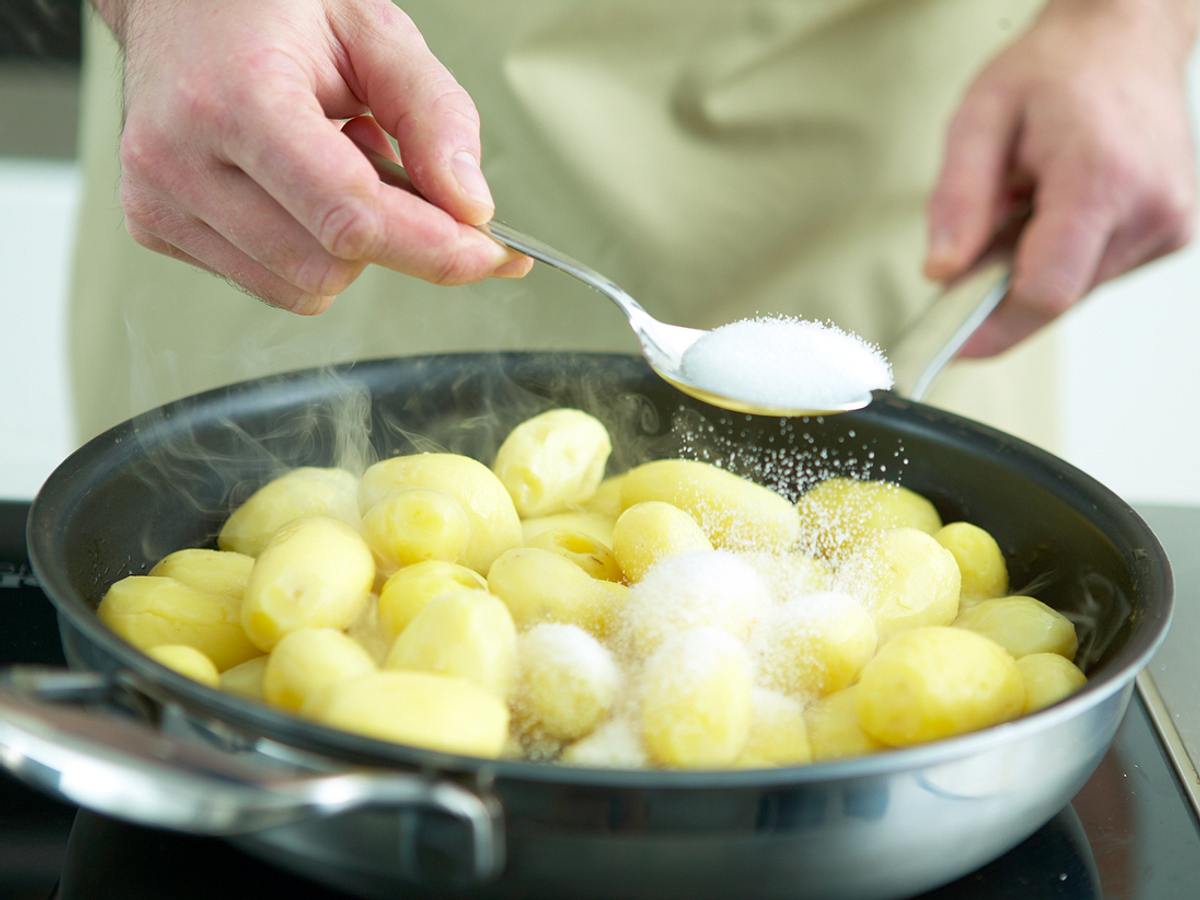 Süße Kartoffeln: Zum Karamellisieren den Zucker über die Kartoffeln streuen