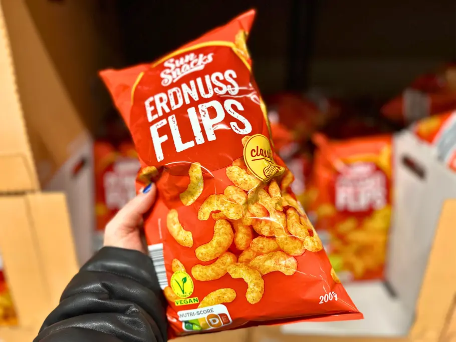 Eine Hand hält eine Tüte Sun Snacks Peanut Flips von Aldi