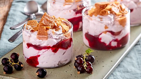 Johannisbeer-Mascarpone-Creme in 2 Gläsern, durchzogen von Johannisbeersoße mit gehackten Waffelröllchen als Topping. - Foto: House of Food / Bauer Food Experts KG