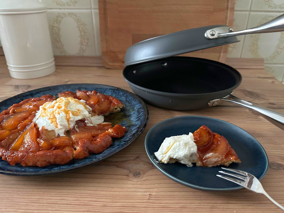 Angeschnittene Tarte Tatin aus der Hagen-Grote-Wendepfanne mit einem Klecks Schlagsahne und Karamell