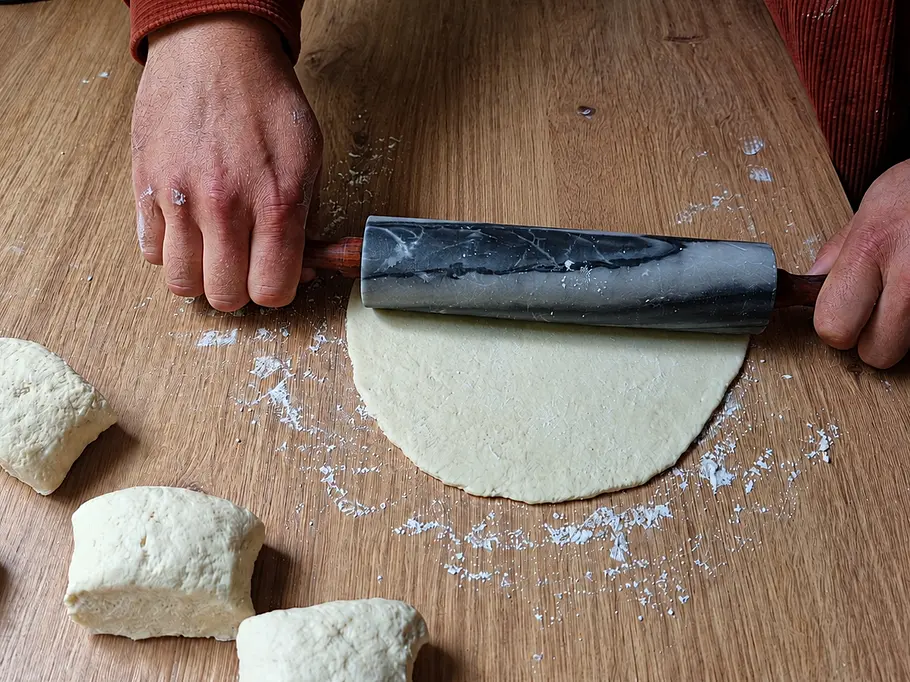 High-Protein Fladenbrot ausrollen Fladenbrot wird auf etwas Mehl in Pfannengröße ausgerollt.
