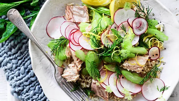 Thunfisch-Reis-Bowl mit Gurke und Radieschen in einer weißen Schale mit Gabel - Foto: LECKER @ Bauer Media Group