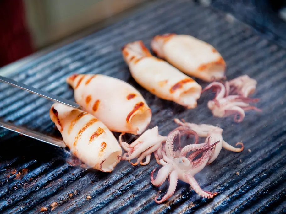Tintenfisch auf dem Grill Tintenfischtuben und kleine Tintenfische auf dem Grill