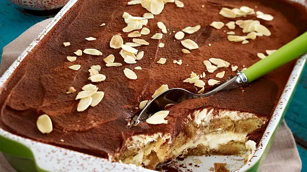 Angeschnittenes Tiramisu ohne Ei mit cremiger Quark-Mascarpone-Creme und Kakaopulver in einer grünen Auflaufform - Foto: LECKER @ Bauer Media Group Angeschnittenes Tiramisu ohne Ei mit cremiger Quark-Mascarpone-Creme und Kakaopulver in einer grünen Auflaufform - Foto: LECKER @ Bauer Media Group