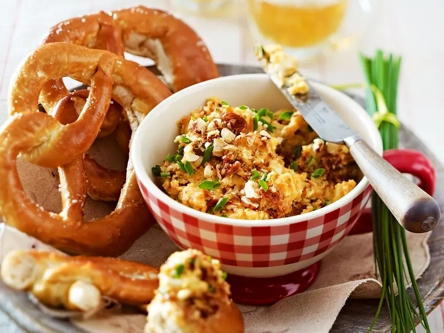 Tomaten-Obatzda Rezept Tomaten-Obatzda in einer Schüssel, serviert mit Brezel.