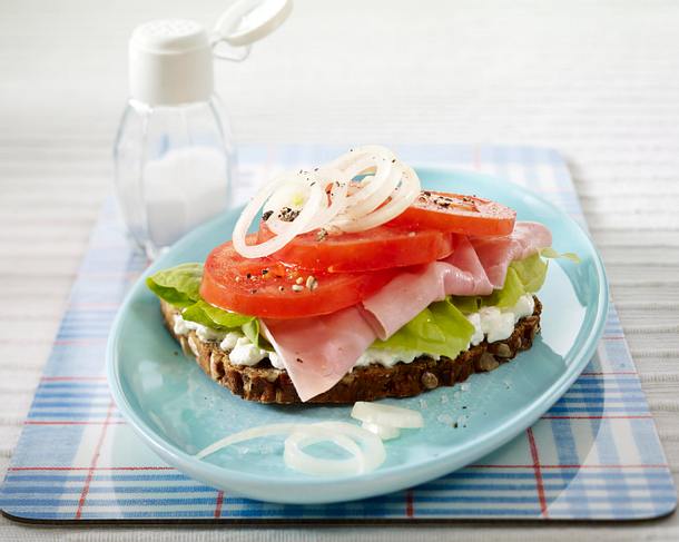 Tomatenbrot mit Ricotta, Kochschinken und Zwiebelringen auf Salatblatt Rezept