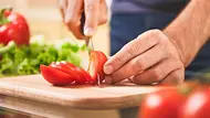 Mann schneidet Tomate mit einem Tomatenmesser - Foto: iStock/takoburito Mann schneidet Tomate mit einem Tomatenmesser - Foto: iStock/takoburito