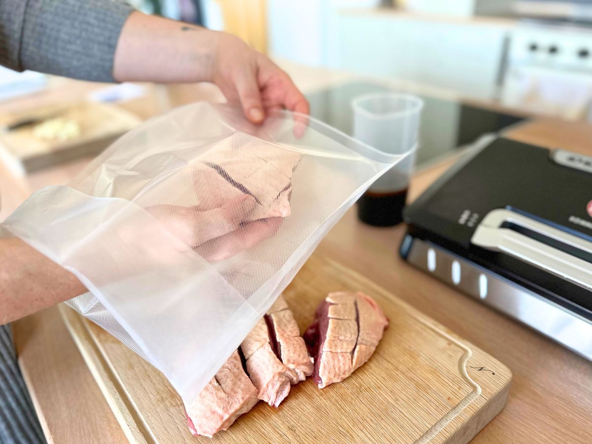 Entenbrust wird in den umgekrempelten Vakuumbeutel gepackt