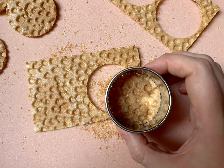 Bueno-Waffel-ausstechen Aus einer Knusperwaffel werden mit einem Ausstecher Kreise ausgestochen