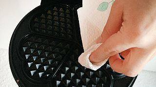 Waffeleisen mit Küchenpapier reinigen