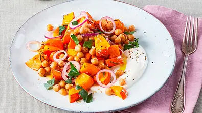 Warmer Kürbissalat mit Kichererbsen und roten Zwiebelringen auf einem weißen Teller. Daneben eine Gabel. - Foto: LECKER @ Bauer Media Group Warmer Kürbissalat mit Kichererbsen und roten Zwiebelringen auf einem weißen Teller. Daneben eine Gabel. - Foto: LECKER @ Bauer Media Group