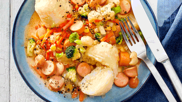 Idee für die Frage: Was koche ich heute?: Würstchengulasch ist mit zwei Kartoffelklößen auf einem Teller serviert. - Foto: House of Food / Bauer Food Experts KG