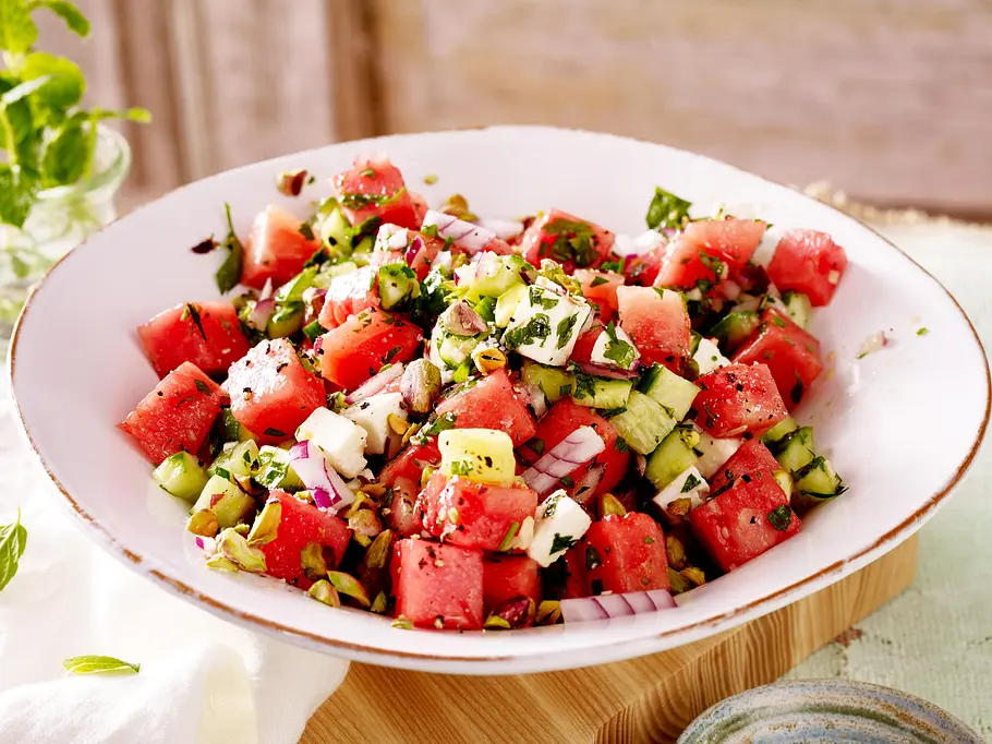 Wassermelonen-Gurken-Salat mit Feta Rezept-F8548703 Wassermelonensalat mit Gurke, Feta, Kräutern und gehackten Pistazien in einer weißen Schüssel.