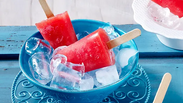 Zwei Wassermelonen-Eis am Stiel in einer blauen Schale mit Eiswürfeln - Foto: LECKER @ Bauer Media Group Zwei Wassermelonen-Eis am Stiel in einer blauen Schale mit Eiswürfeln - Foto: LECKER @ Bauer Media Group