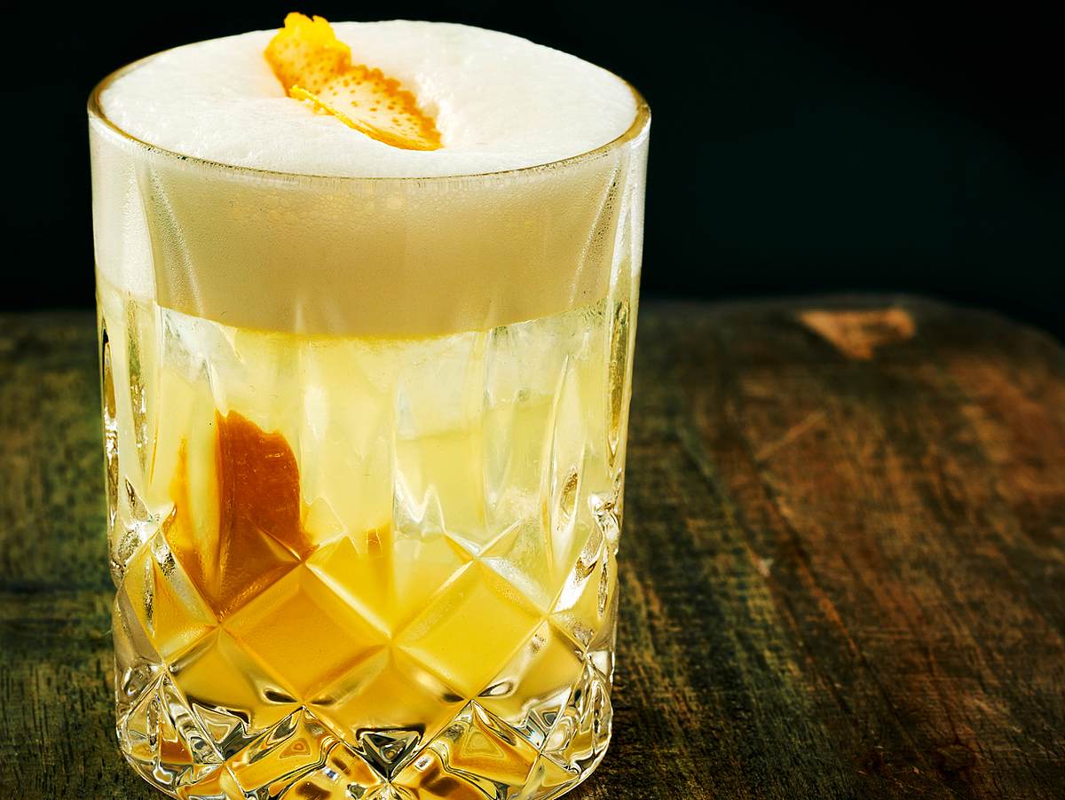 Whiskey Sour mit Schaumkrone und einer Orangenschale
