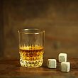 Whisky-Steine und gefülltes Whisky-Glas auf Holztisch - Foto: iStock/JurgaR